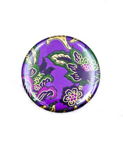 Round pocket mirror featuring green and purple sarasa flowers on a pearlescent purple background with metallic gold accents.