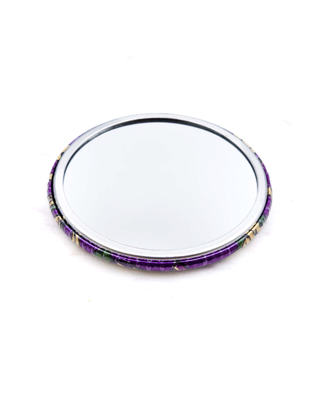 Round pocket mirror featuring green and purple sarasa flowers on a pearlescent purple background with metallic gold accents.