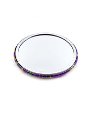 Round pocket mirror featuring green and purple sarasa flowers on a pearlescent purple background with metallic gold accents.