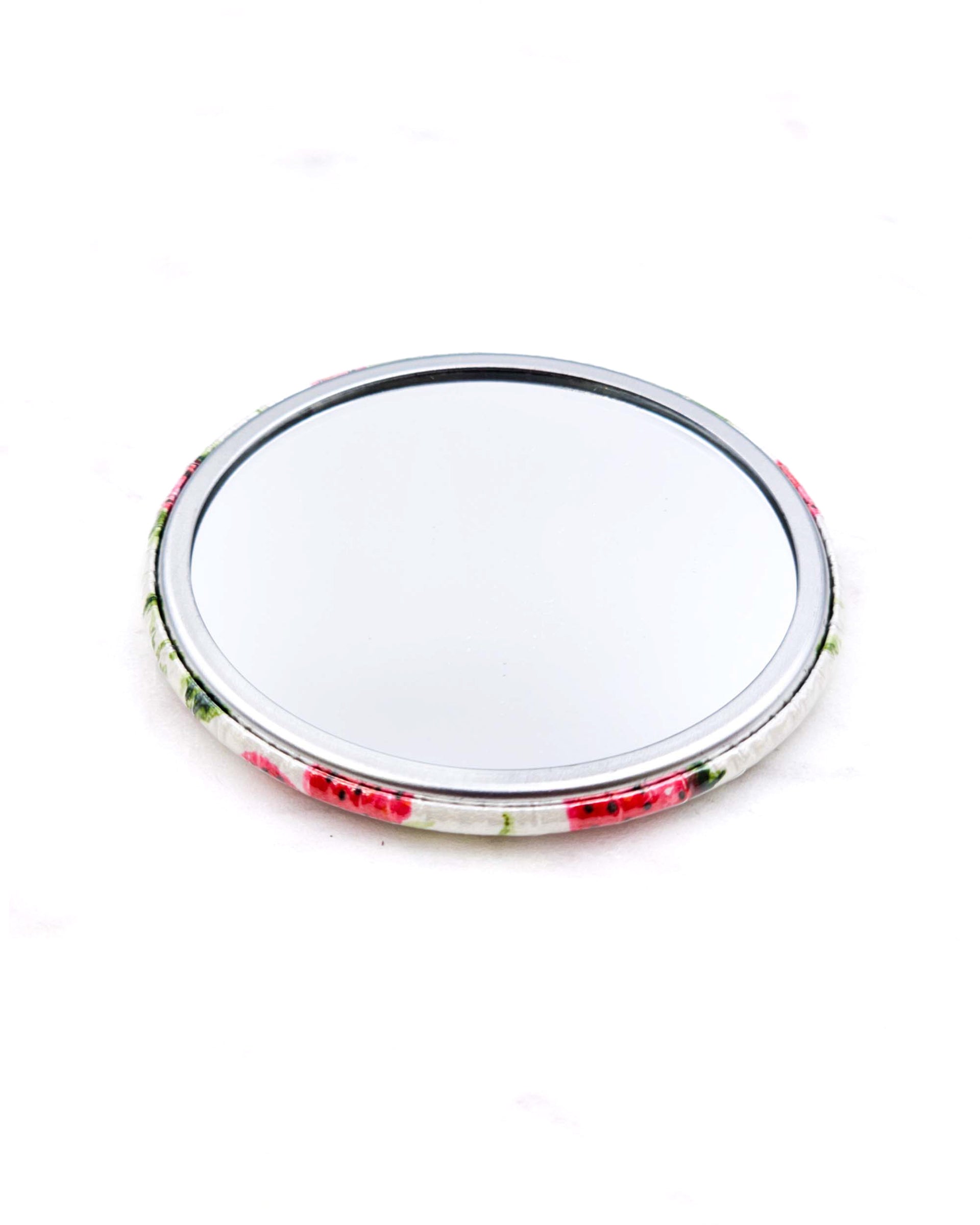 Round pocket mirror featuring strawberries and white flowers on a pearlescent white background.
