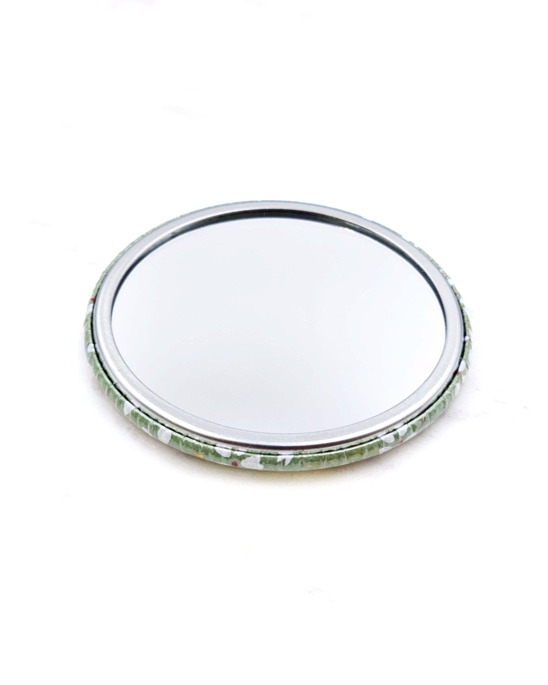 Round pocket mirror featuring small white and gold cherry blossoms on a light green background with metallic gold accents.