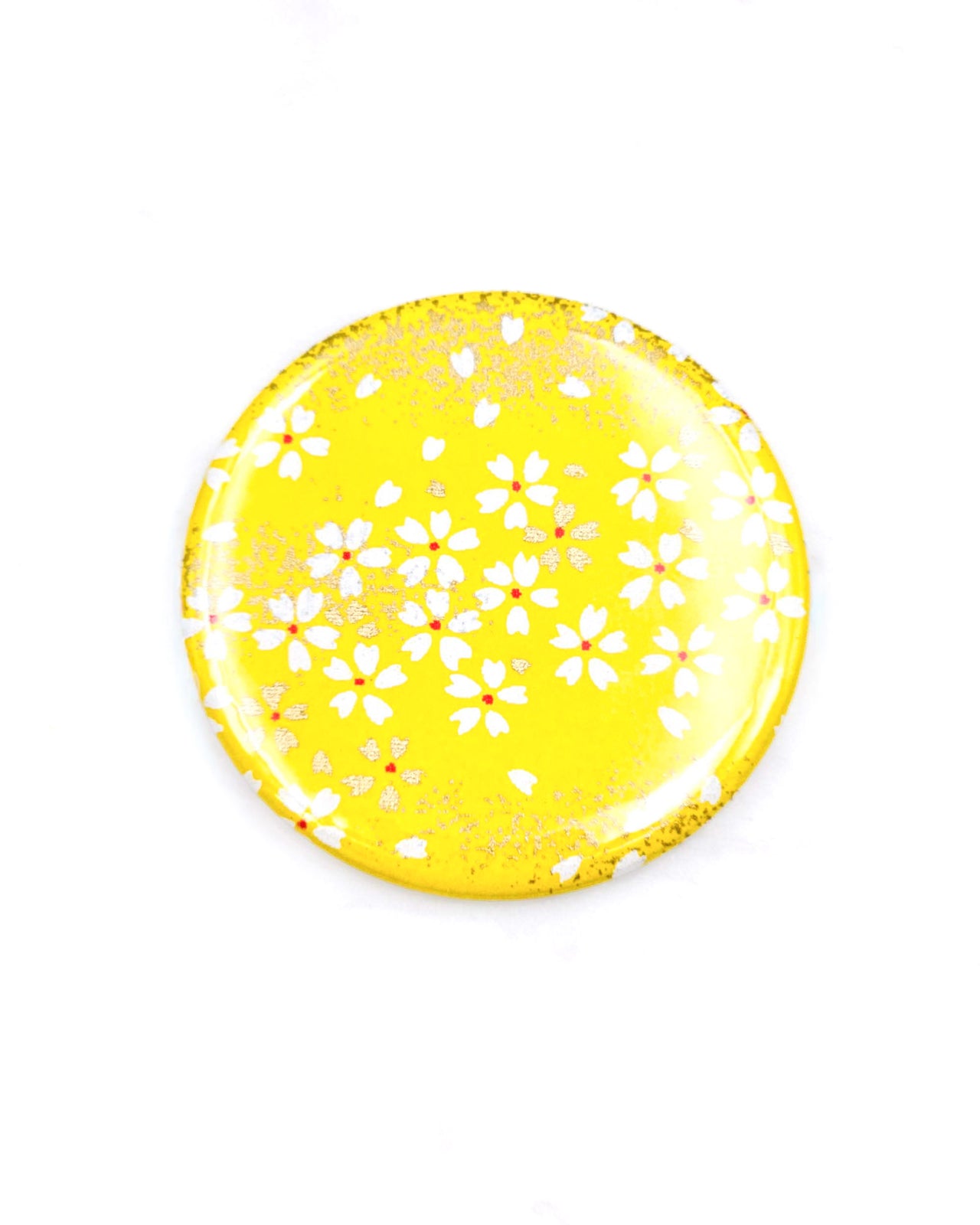 Round pocket mirror featuring small white and gold cherry blossoms on a yellow background with metallic gold accents.