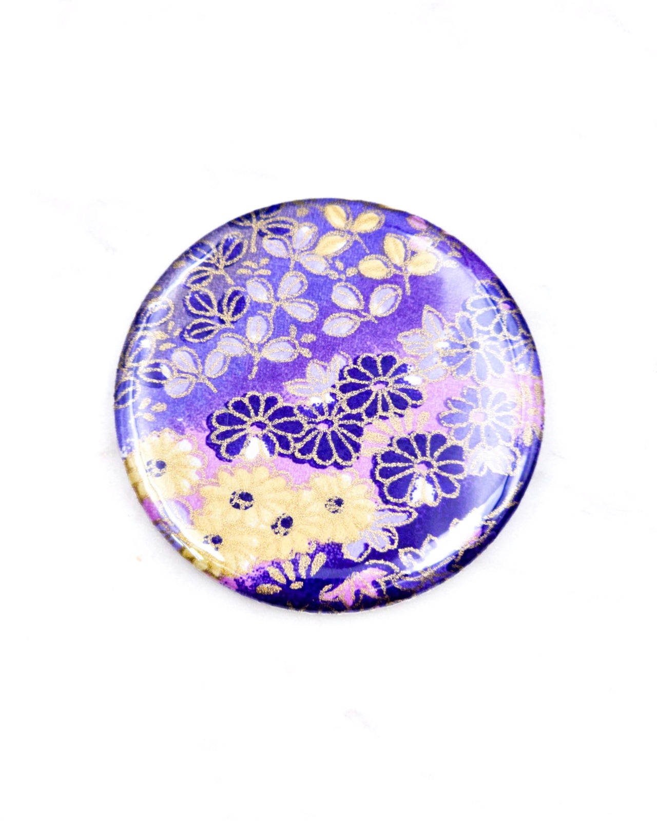 Round pocket mirror featuring yellow and purple flowers on a purple background with metallic gold accents.