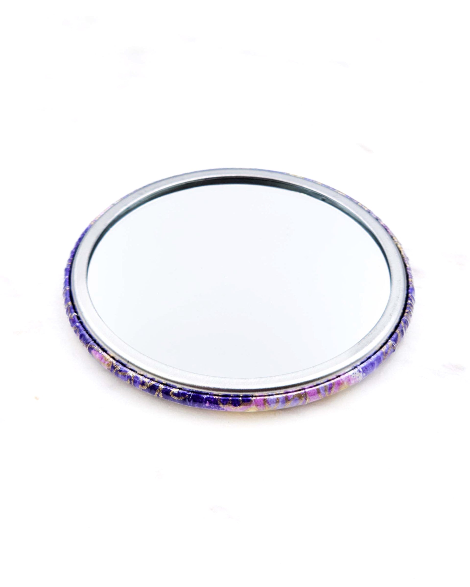 Round pocket mirror featuring yellow and purple flowers on a purple background with metallic gold accents.