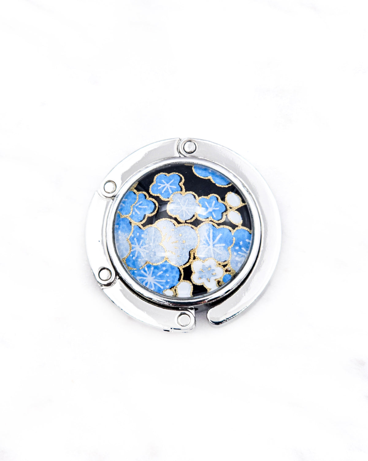 Round silver metal tabletop bag hanger featuring blue and white plum blossoms on a black background with metallic gold details.