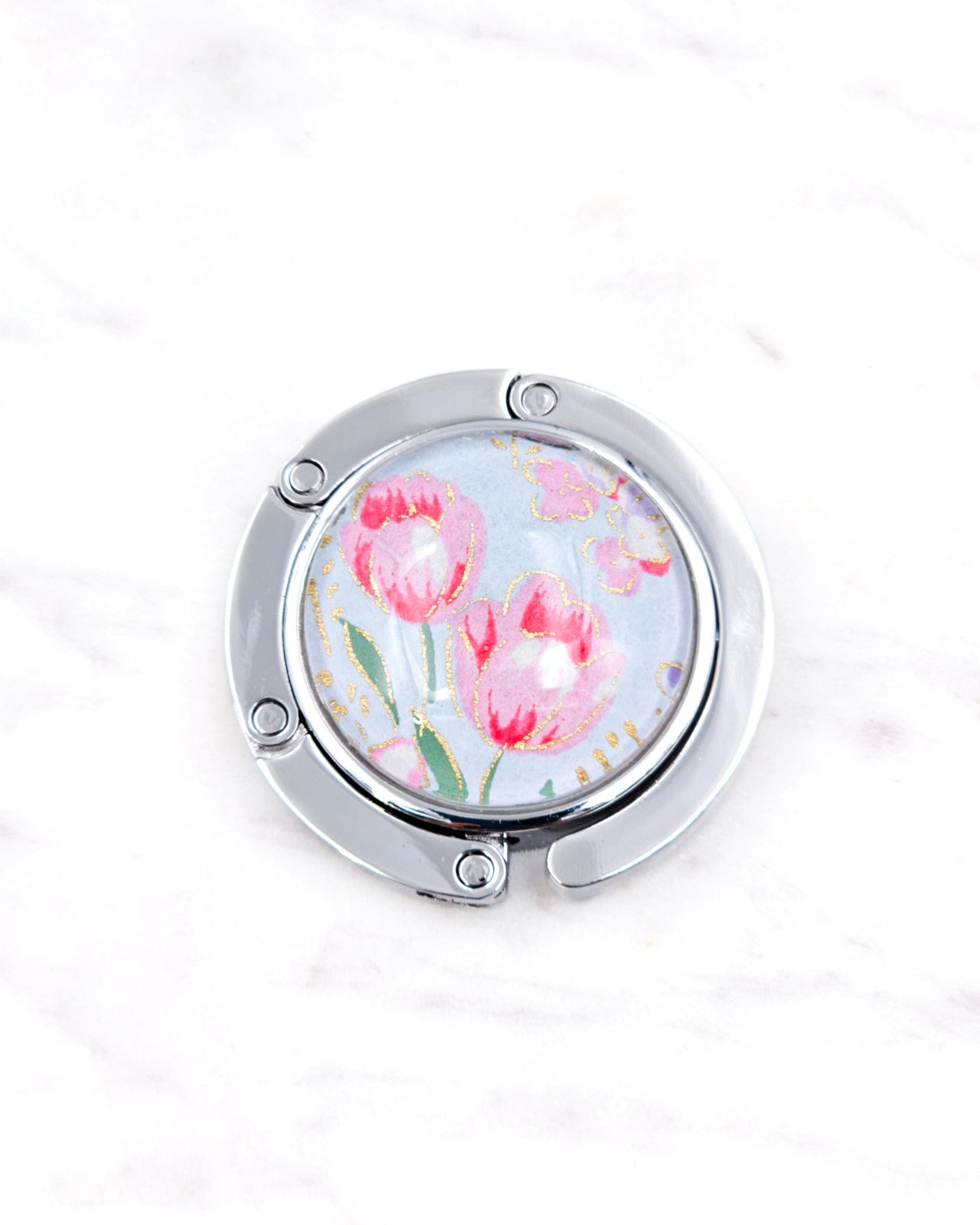 Silver metal table-top bag hanger featuring pink tulips on a light blue background with metallic gold accents.