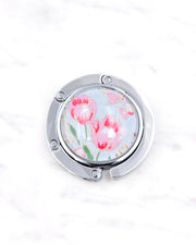 Silver metal table-top bag hanger featuring pink tulips on a light blue background with metallic gold accents.