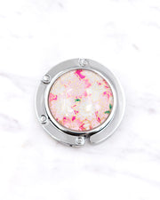 Silver metal table-top bag hanger featuring pink and white cherry blossoms on a pink background with metallic gold accents.