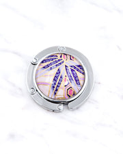 Silver metal table-top bag hanger featuring purple bamboo leaves on a purple background with metallic gold accents.