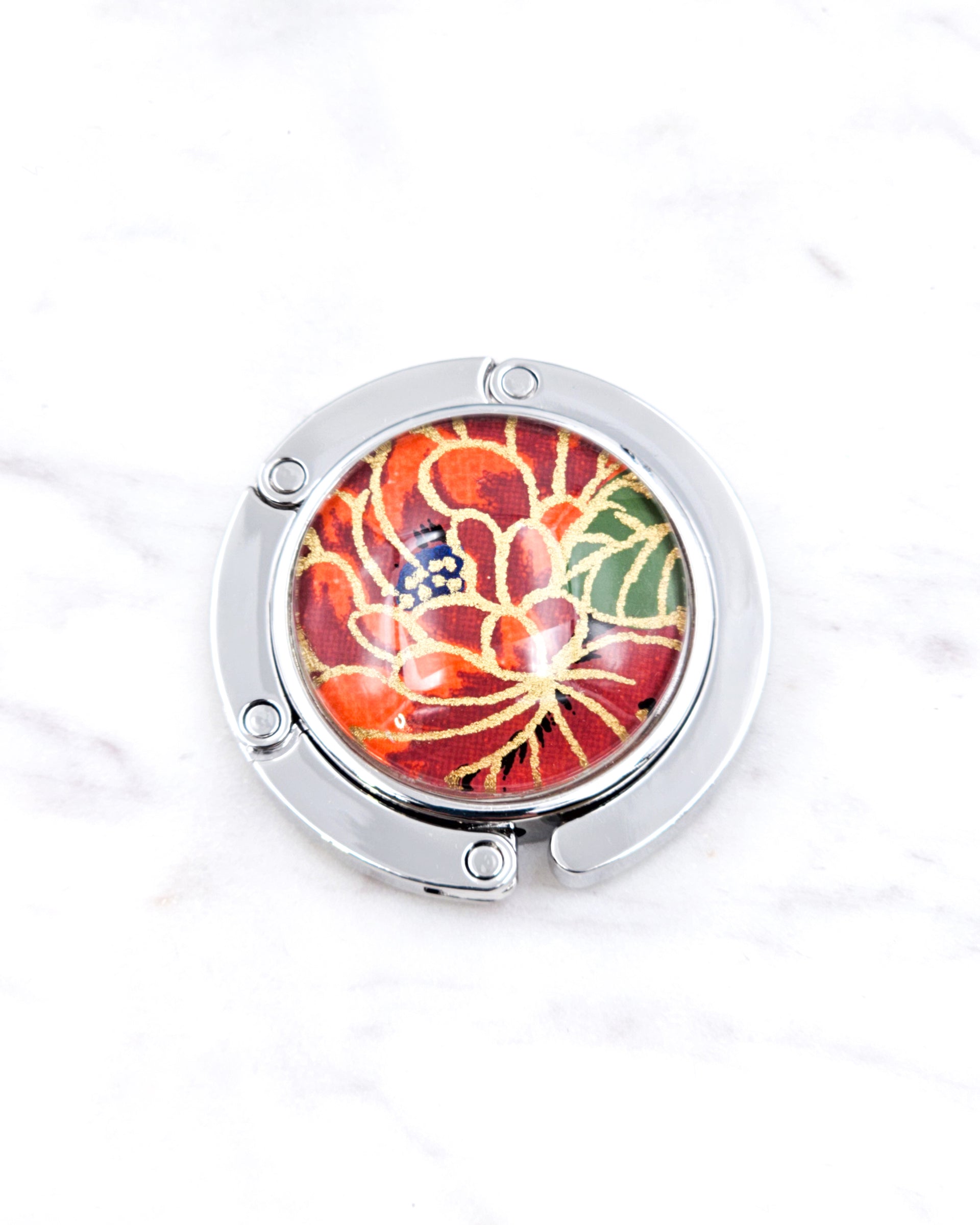 Silver metal table-top bag hanger featuring a red chrysanthemum flower with metallic gold accents.
