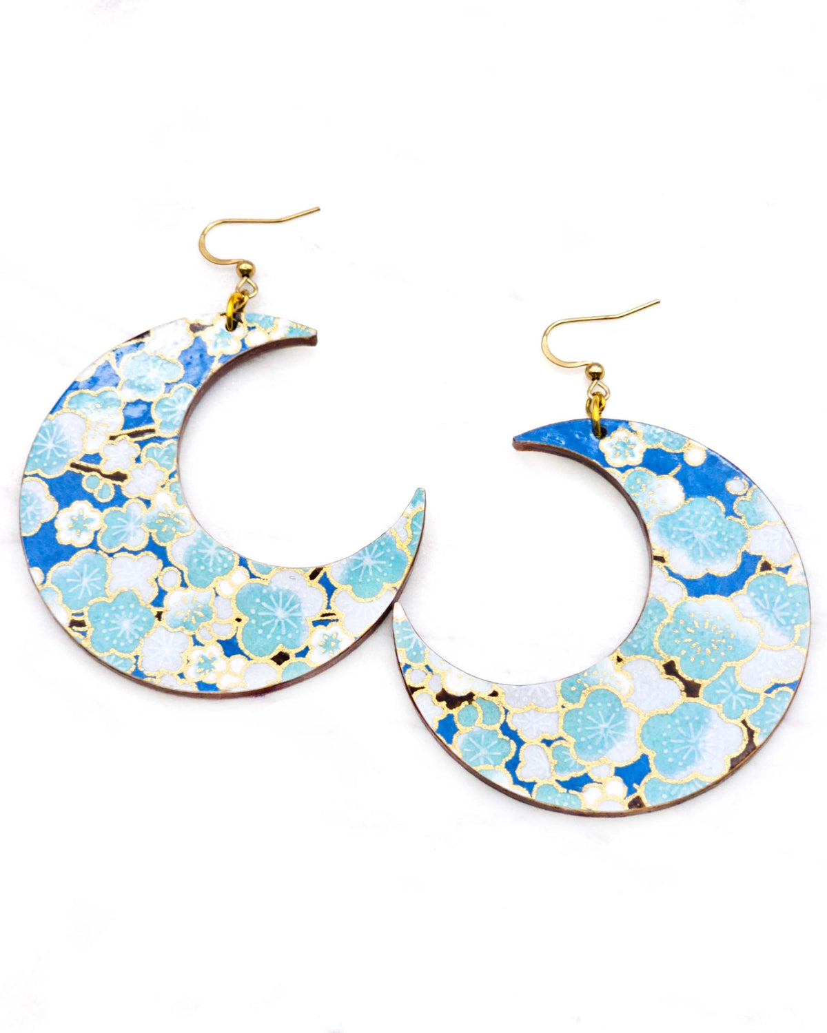 X-Large wooden Crescent Moon shaped earrings featuring turquoise blue and white plum blossom tree with dark brown branches on a blue background with metallic gold details.