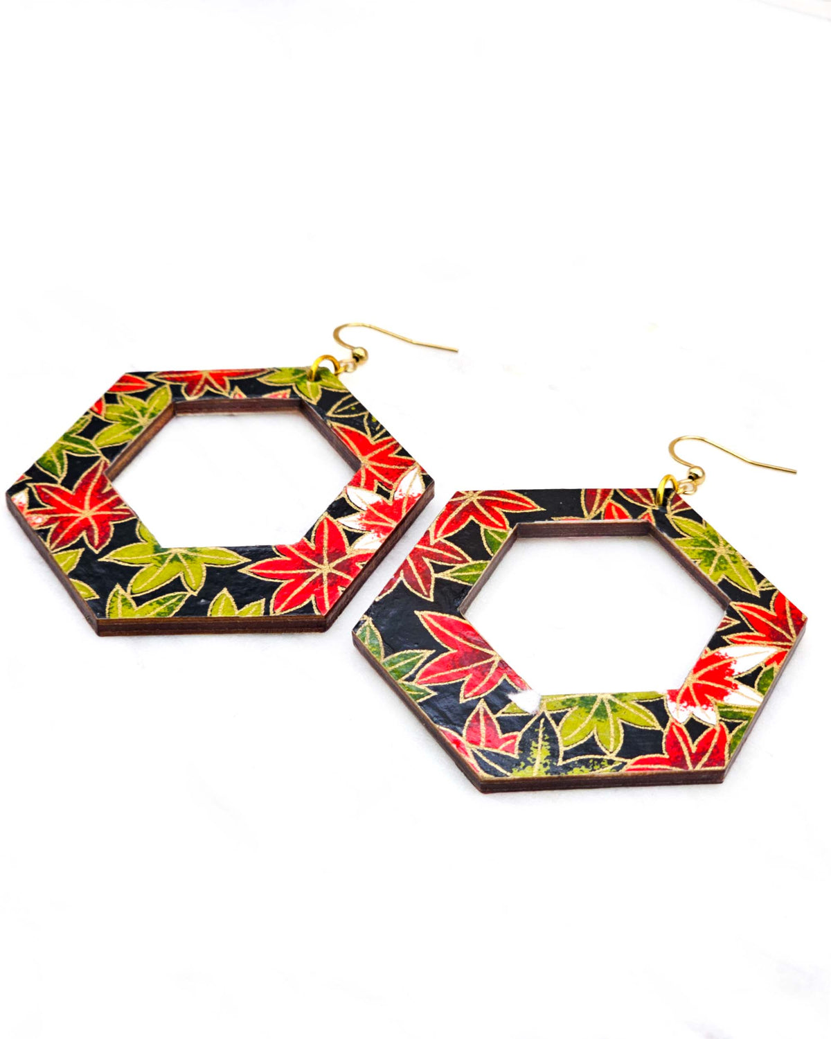 X-Large wooden hollow hexagon shaped earrings featuring red, green, and white maples leaves on a black background with metallic gold details.