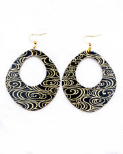 X-Large wooden abstract hoop shaped earrings featuring metallic gold water ripples on a black background.
