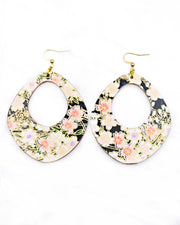 X-Large wooden abstract hoop shaped earrings featuring pink cherry blossoms and white cherry blossoms with purple and pink centers on a black background with metallic gold details.