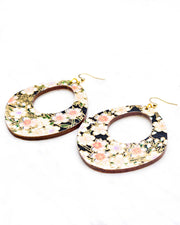 X-Large wooden abstract hoop shaped earrings featuring pink cherry blossoms and white cherry blossoms with purple and pink centers on a black background with metallic gold details.