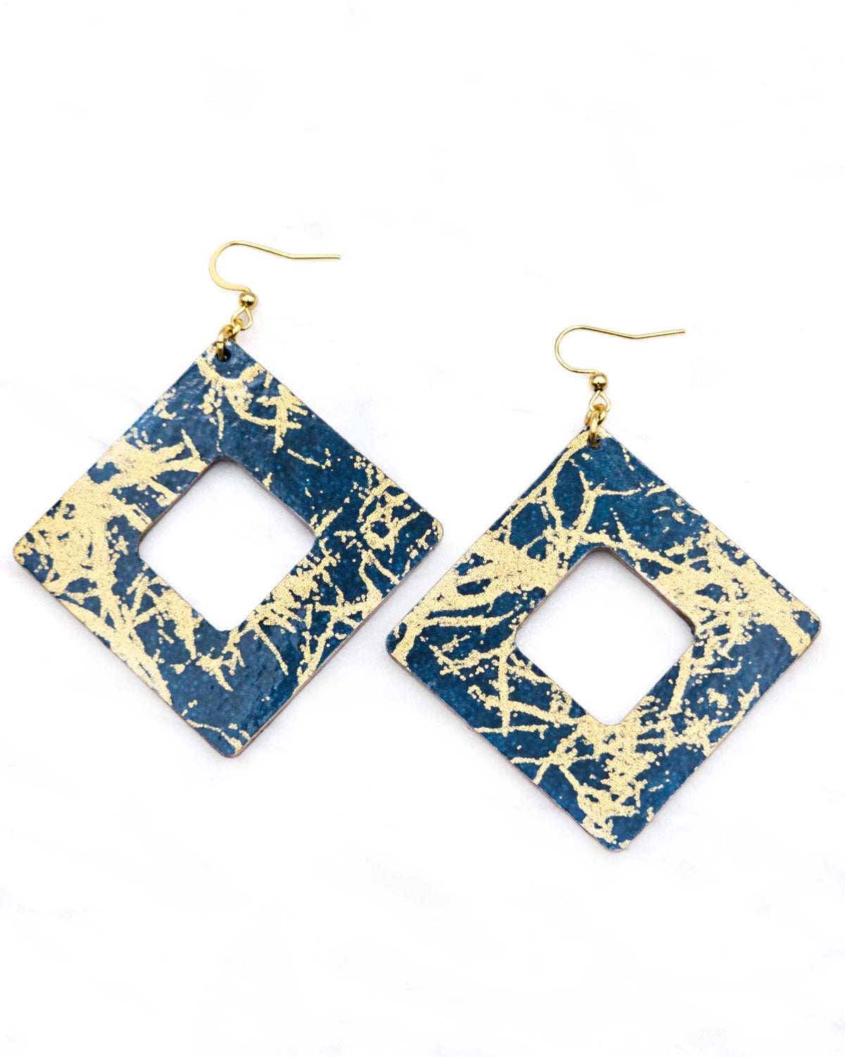 X-Large wooden hollow square diamond shaped earrings featuring metallic gold fibers in the style of traditional unryu paper on a dark blue background.