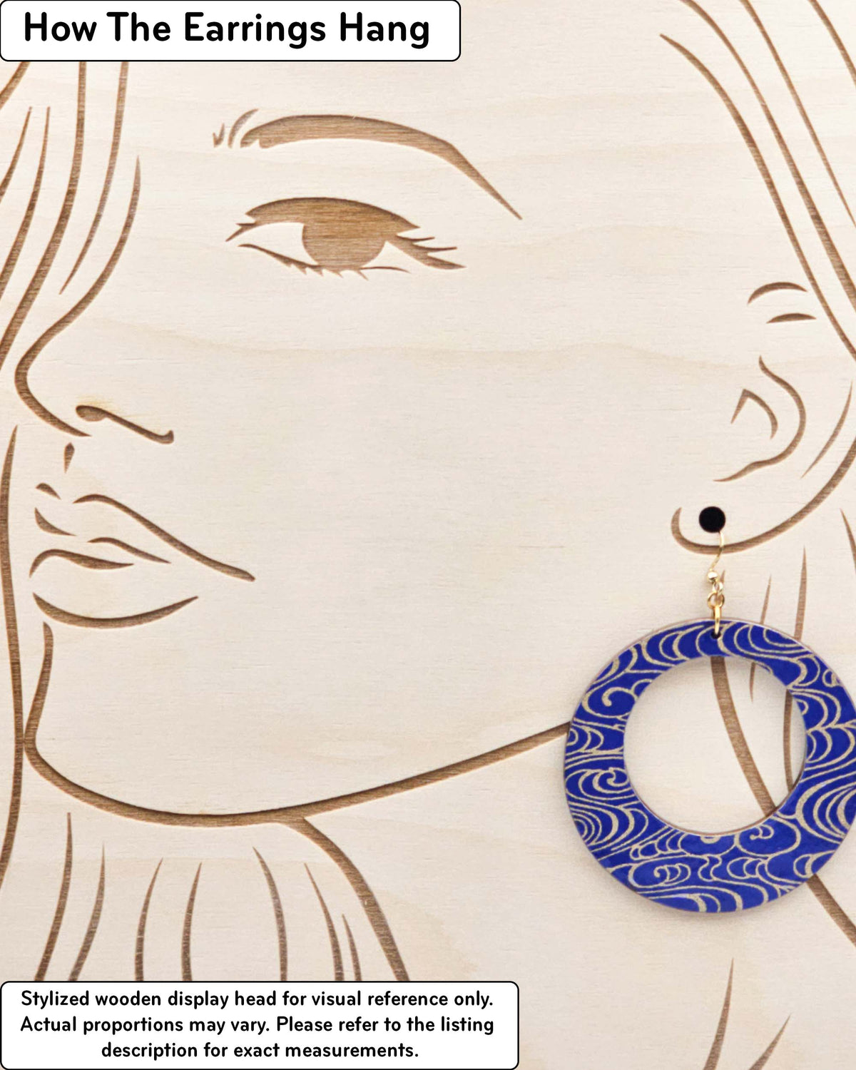 X-Large wooden round hoop shaped earrings featuring metallic gold water ripples on a dark blue background, displayed on a stylized wooden head to demonstrate how the earring hangs when worn. Display is not to scale.