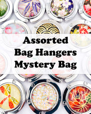 An assortment of silver metal table-top bag hangers