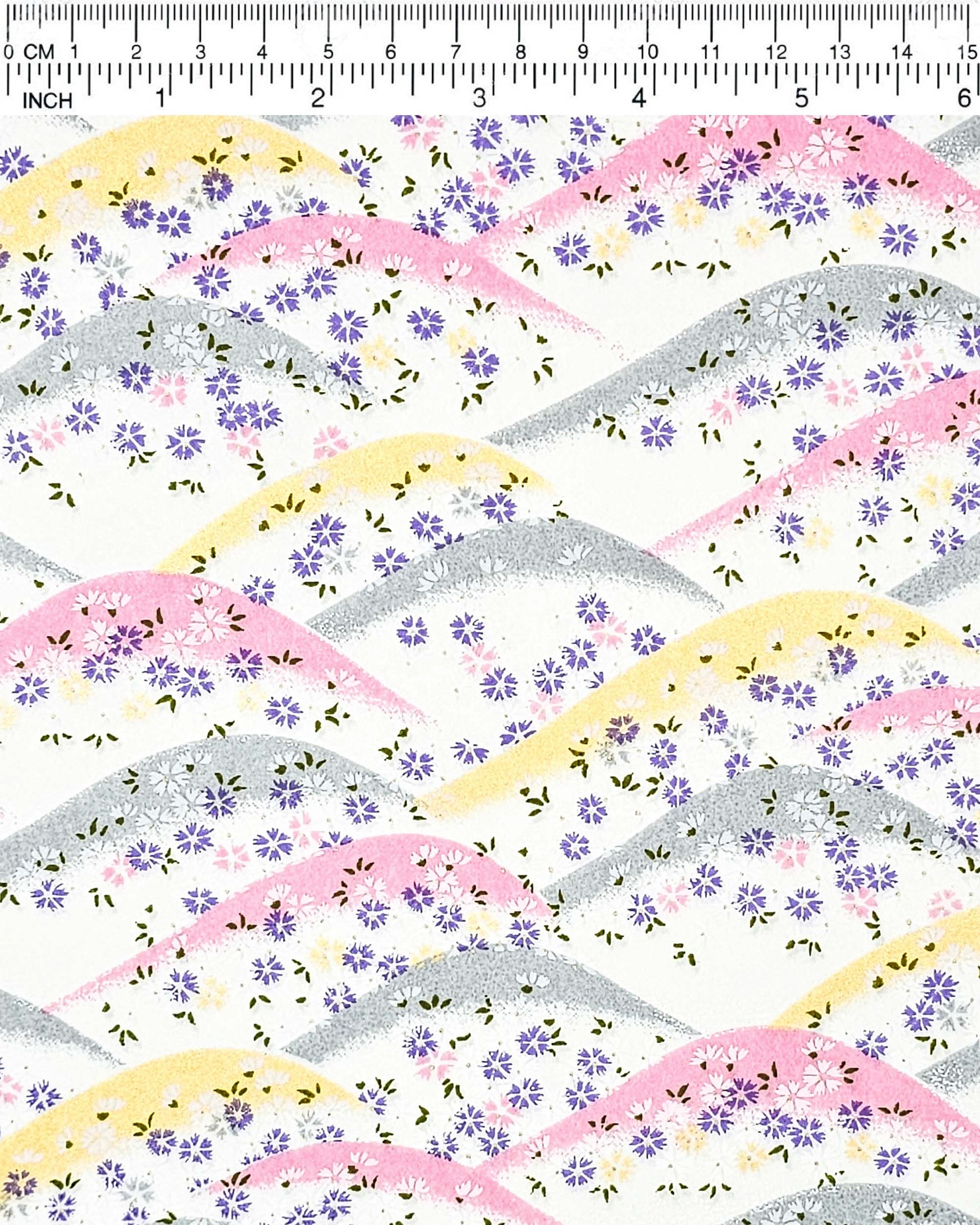 Japanese chiyogami paper featuring pink, gray, and gold hills with purple, pink, and white cherry blossoms on a white background with metallic gold details