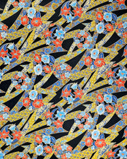 Japanese chiyogami paper featuring red and blue flowers intertwined in yellow and blue ribbons with a shippo floral pattern on a black background with metallic gold details.
