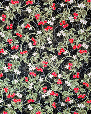 Japanese chiyogami paper featuring red cherries with white flowers and green leaves on a black background with metallic gold details.