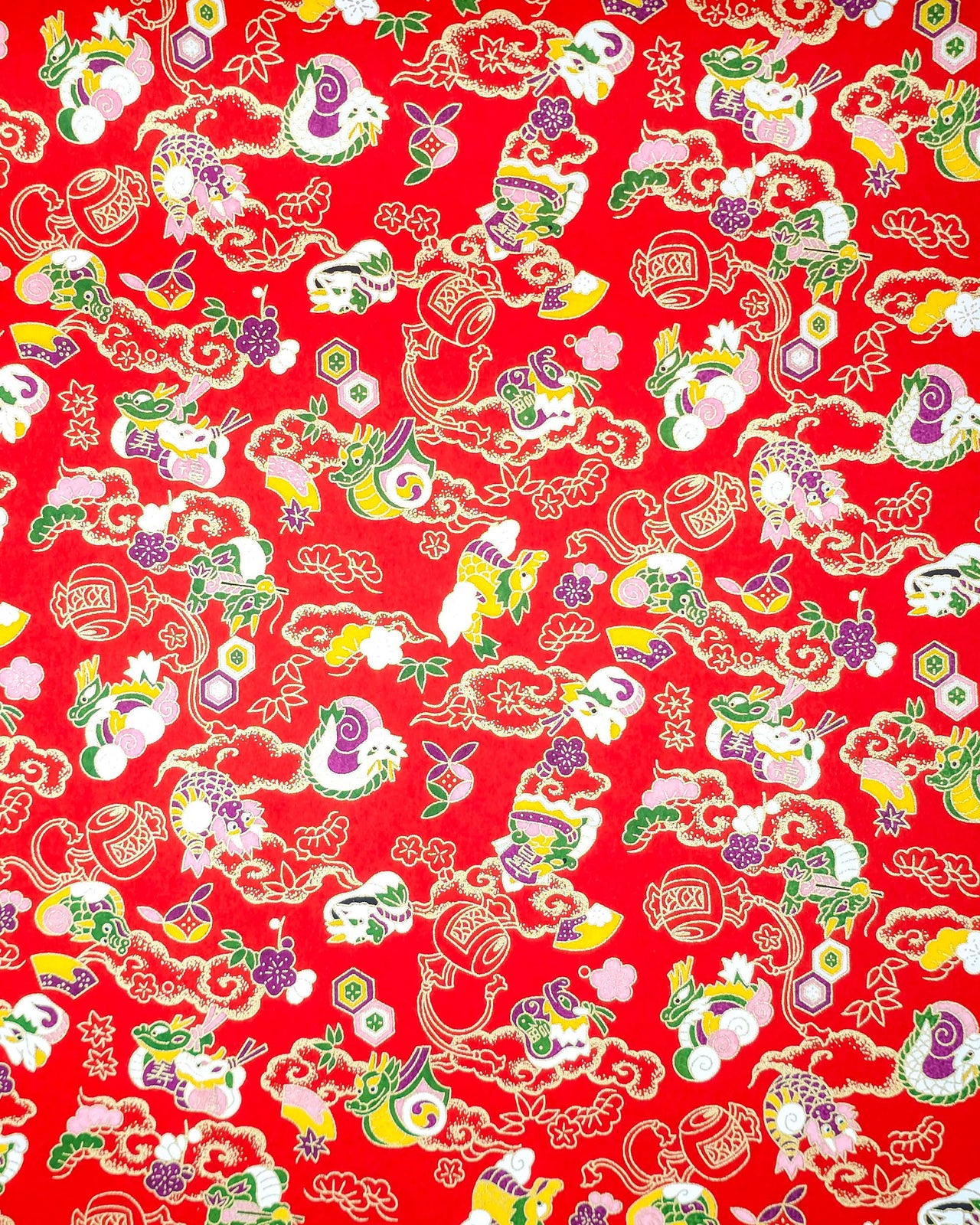 Japanese chiyogami paper featuring assorted white, purple, green, and yellow dragons on a red background with metallic gold details.