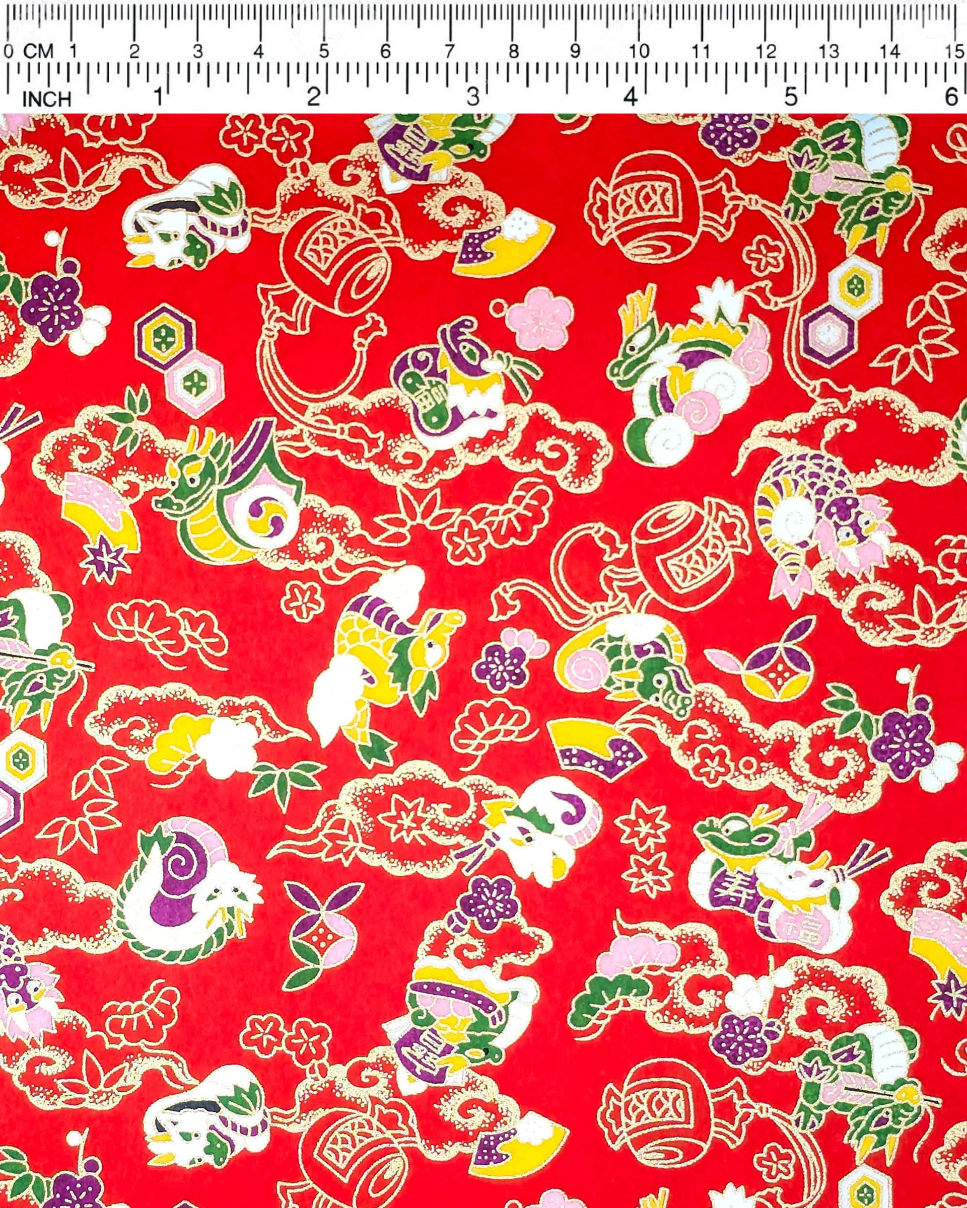 Japanese chiyogami paper featuring assorted white, purple, green, and yellow dragons on a red background with metallic gold details.