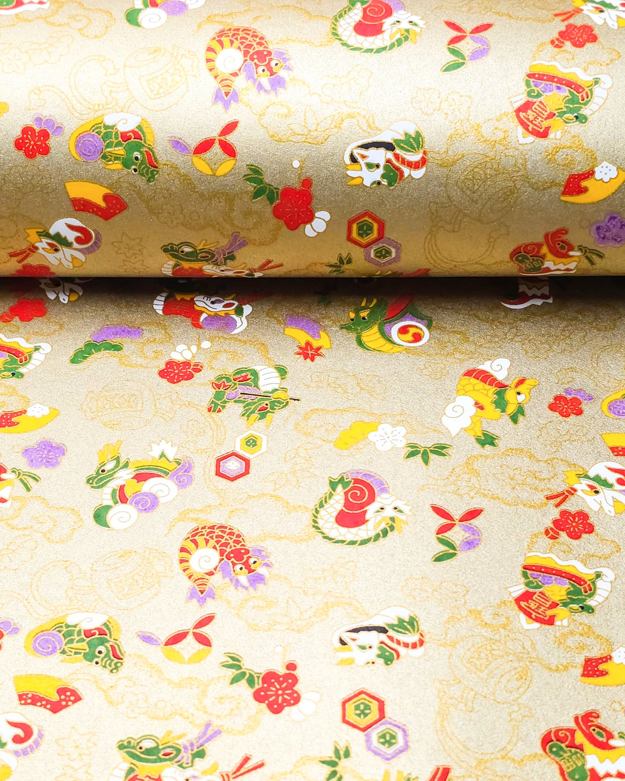 Japanese chiyogami paper featuring assorted white, purple, green, red, and yellow dragons on a gold background with metallic gold details.