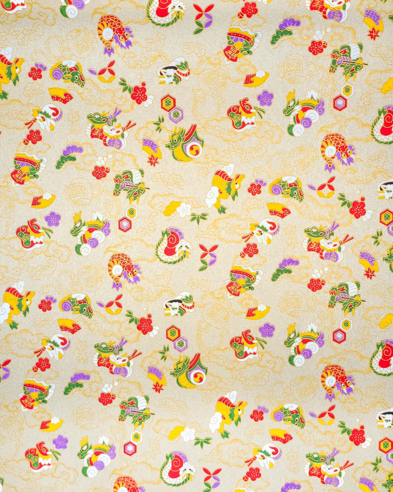 Japanese chiyogami paper featuring assorted white, purple, green, red, and yellow dragons on a gold background with metallic gold details.