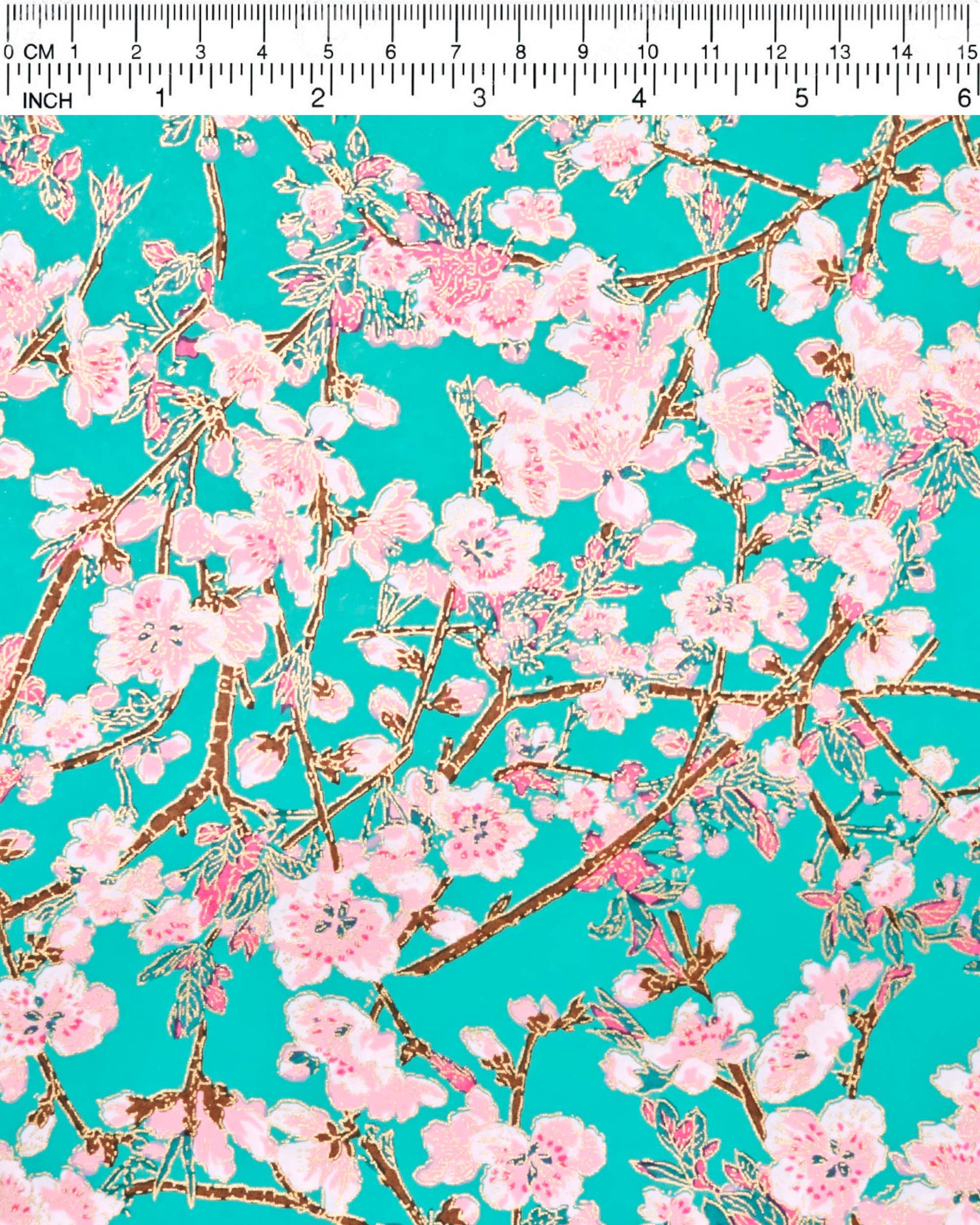 Japanese chiyogami paper featuring pink and white detailed plum blossoms with brown branches and green leaves on a turquoise background with metallic gold details.