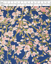 Japanese chiyogami paper featuring pink and white detailed plum blossoms with brown branches and green leaves on a dark blue background with metallic gold details.