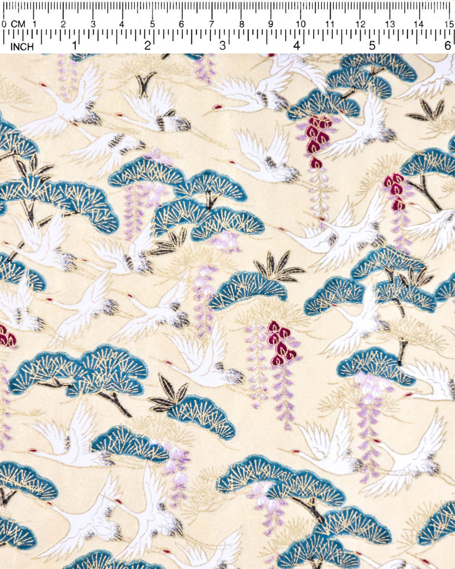 Japanese chiyogami paper featuring white flying cranes, purple and red wisteria, and green pine on a light shimmering gold background with metallic gold details.