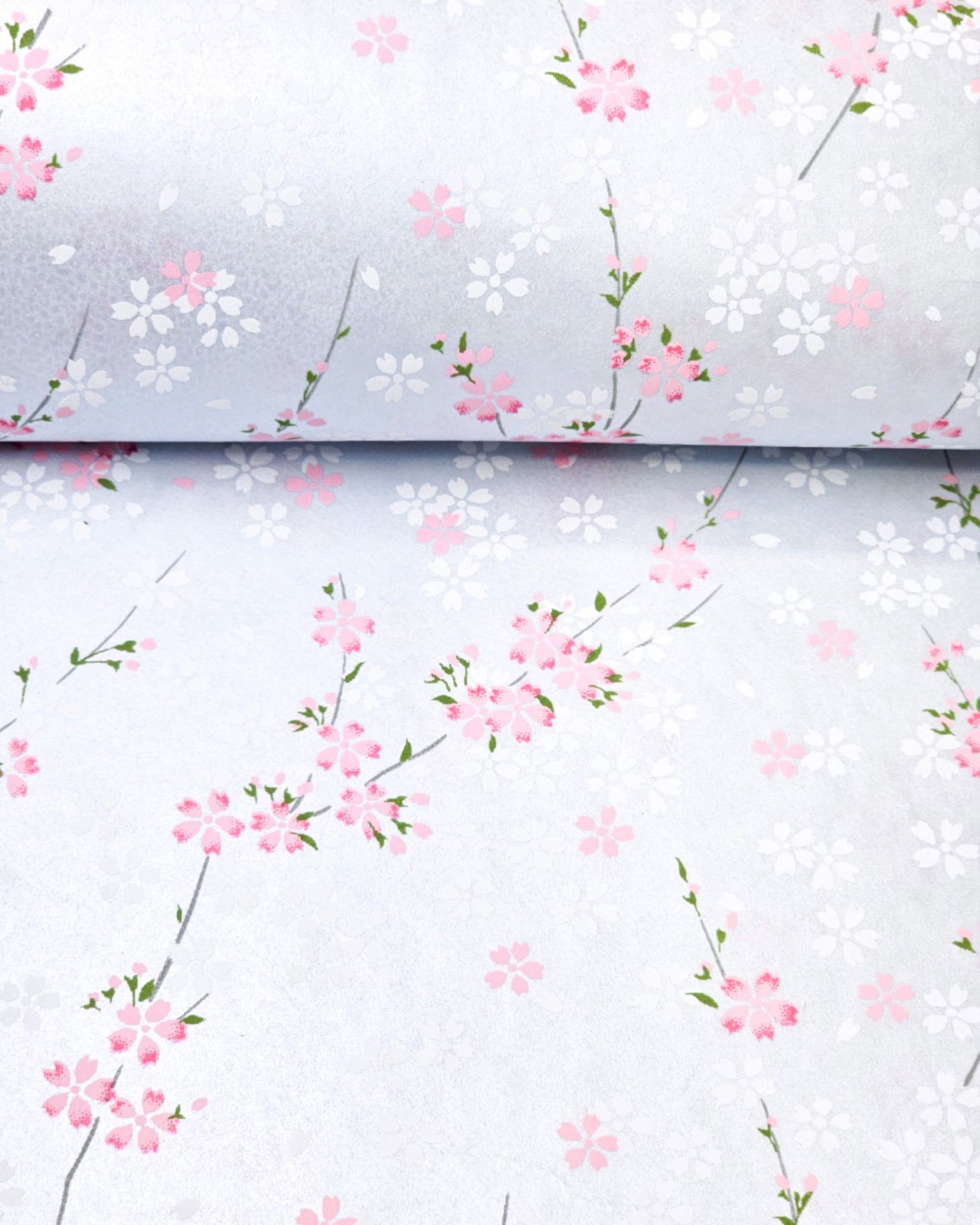Japanese chiyogami paper featuring pink and white cherry blossoms on a pearlescent pale blue gray background.