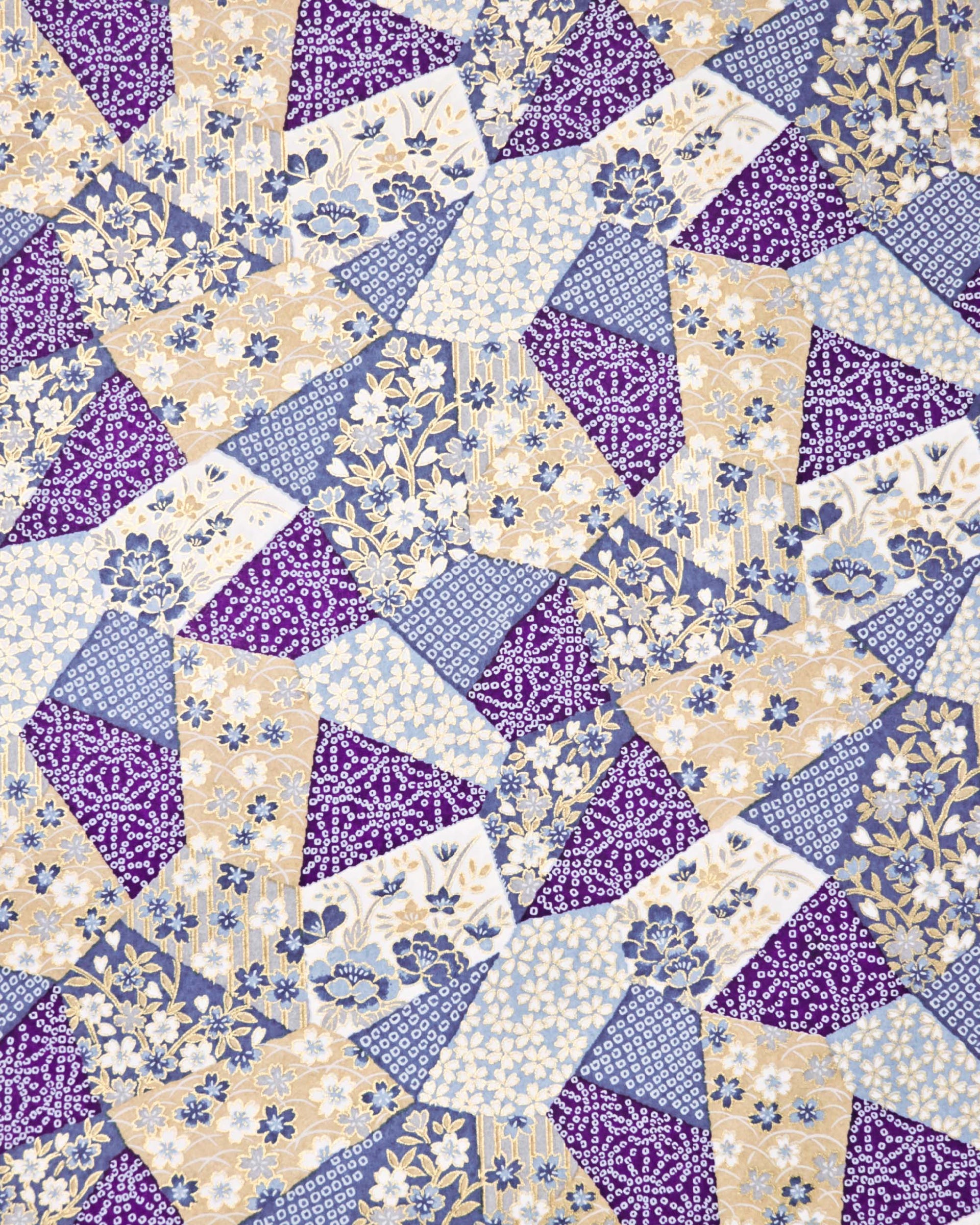 Japanese chiyogami paper featuring blue, beige, white, and purple patches embedded assorted geometric and floral designs with metallic gold details.