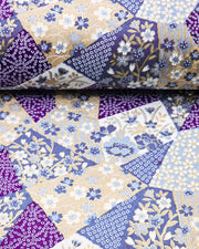 Japanese chiyogami paper featuring blue, beige, white, and purple patches embedded assorted geometric and floral designs with metallic gold details.