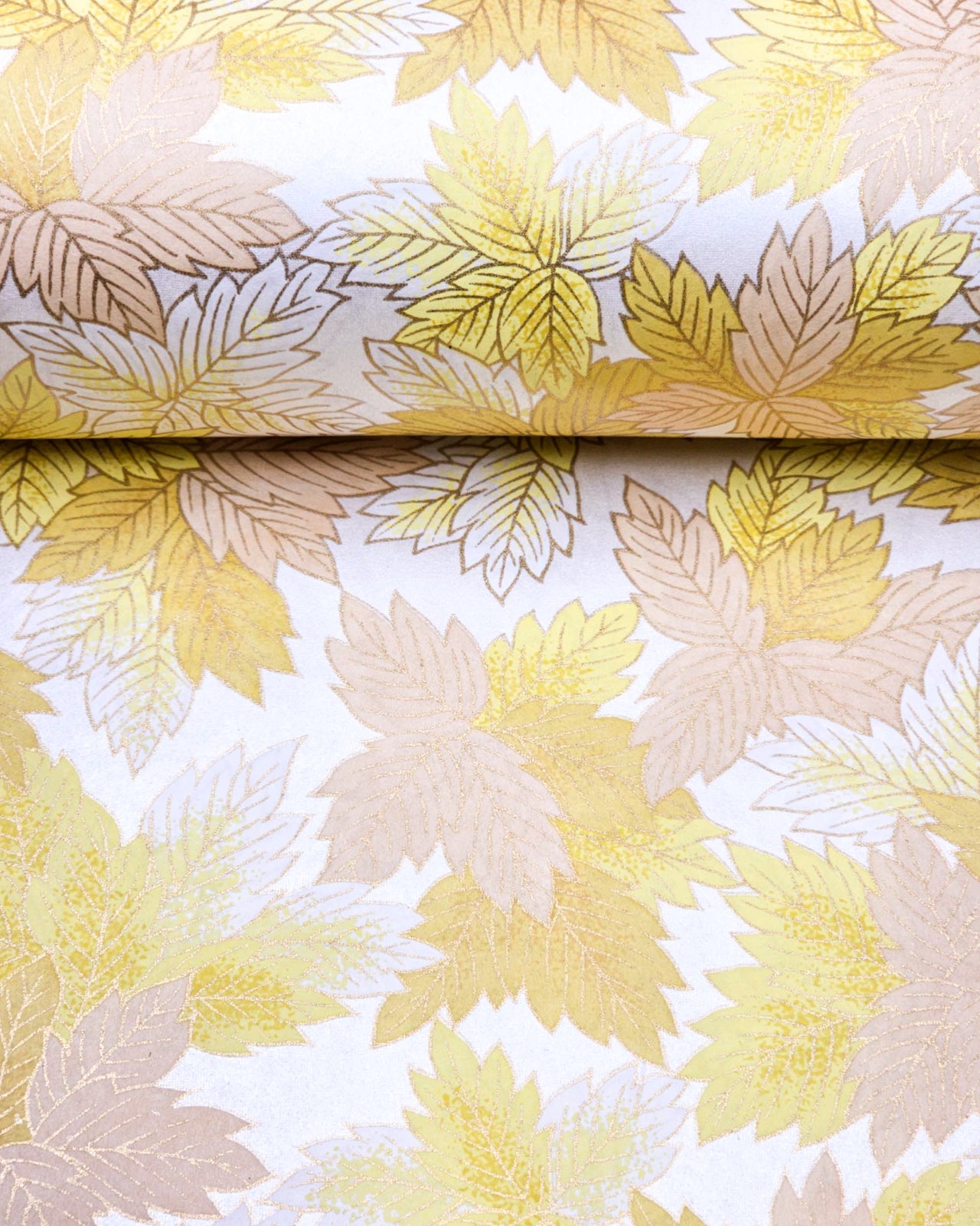 Japanese chiyogami paper featuring large yellow, beige, and white leaves on a pearlescent white background with metallic gold details.