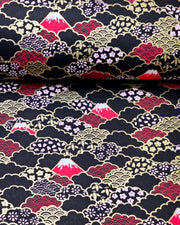 Japanese chiyogami paper featuring red Mt Fuji and gold clouds filled with assorted gold and pink geometric and flower designs on a black background.