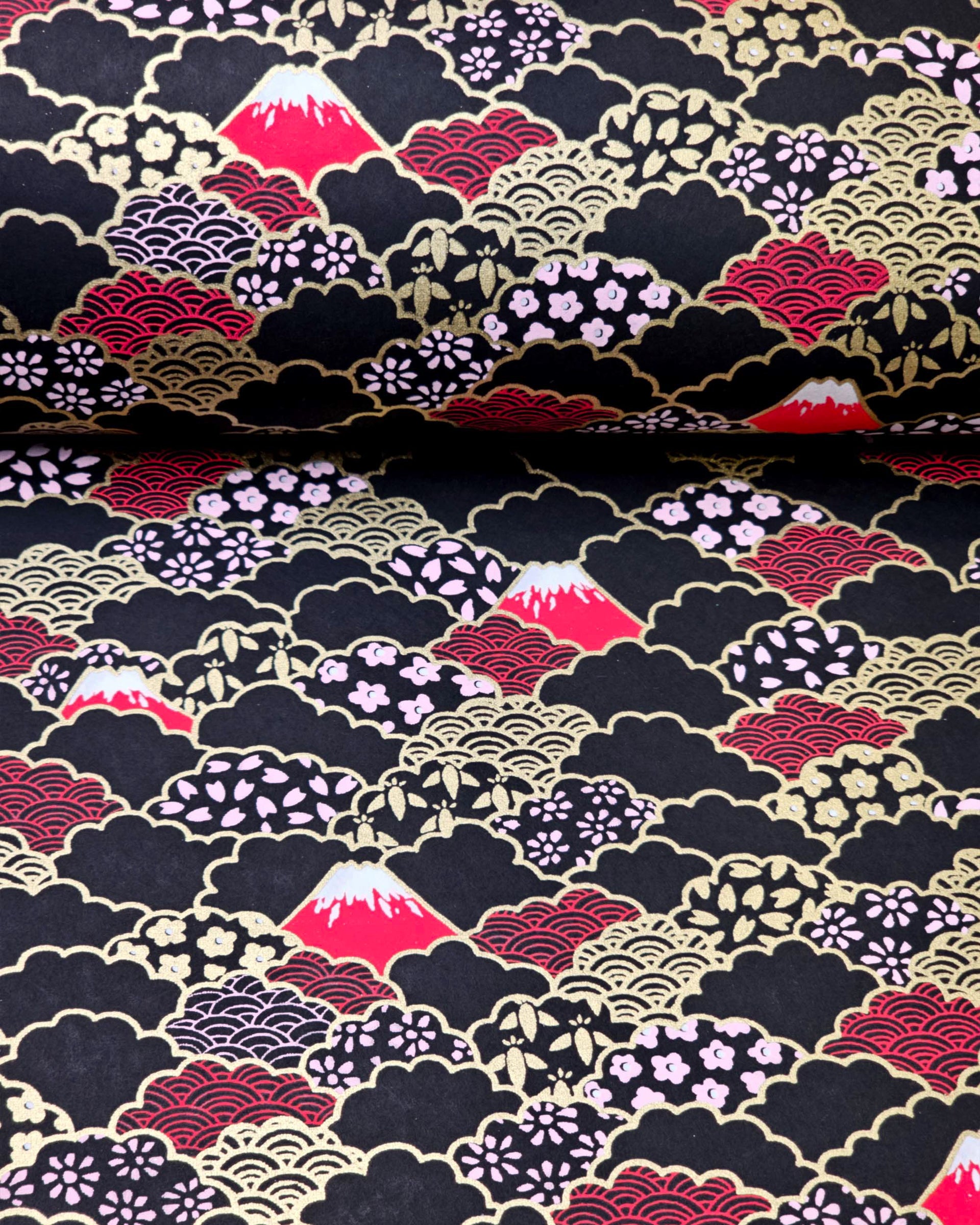 Japanese chiyogami paper featuring red Mt Fuji and gold clouds filled with assorted gold and pink geometric and flower designs on a black background.