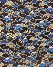 Japanese chiyogami paper featuring blue Mt Fuji and gold clouds filled with assorted gold and blue geometric and flower designs on a black background.