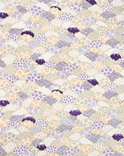 Japanese chiyogami paper featuring dark blue Mt Fuji and gold clouds filled with assorted gold, orange, and purple geometric and flower designs on a white background.