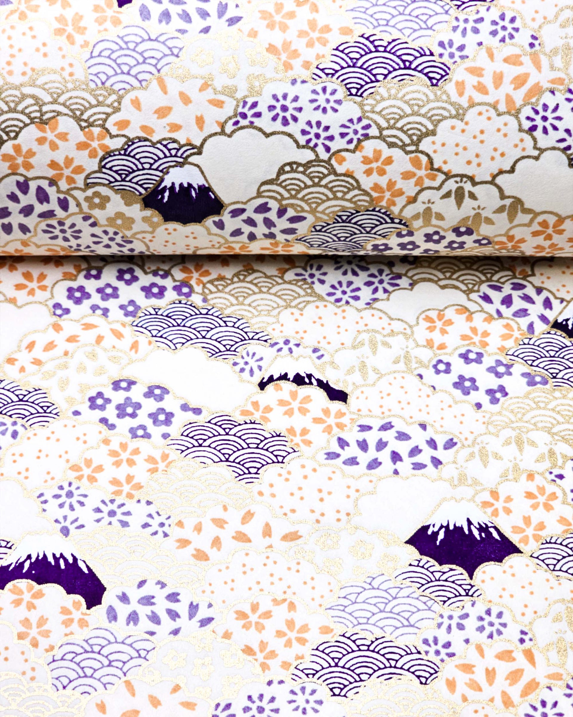Japanese chiyogami paper featuring dark blue Mt Fuji and gold clouds filled with assorted gold, orange, and purple geometric and flower designs on a white background.