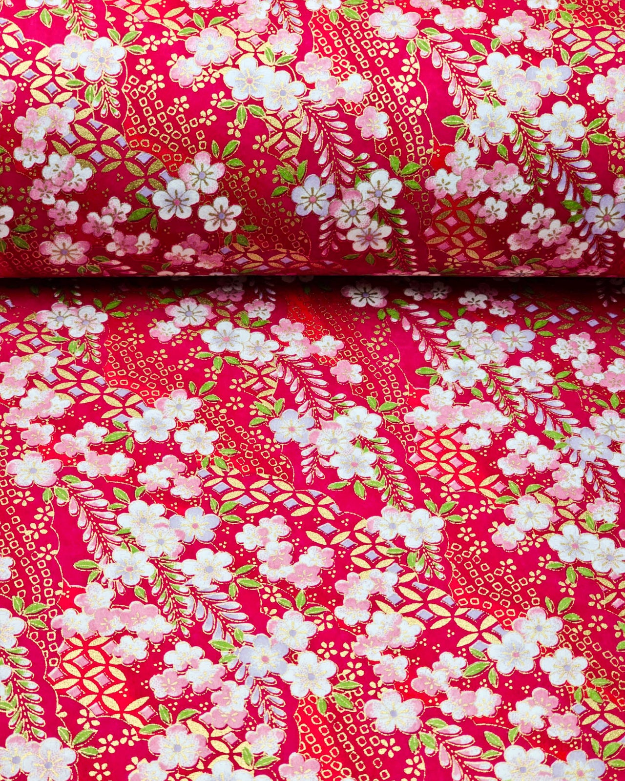 Japanese chiyogami paper featuring pink and purple plum blossoms and pink, green, and purple wisteria on a red background with metallic gold details.