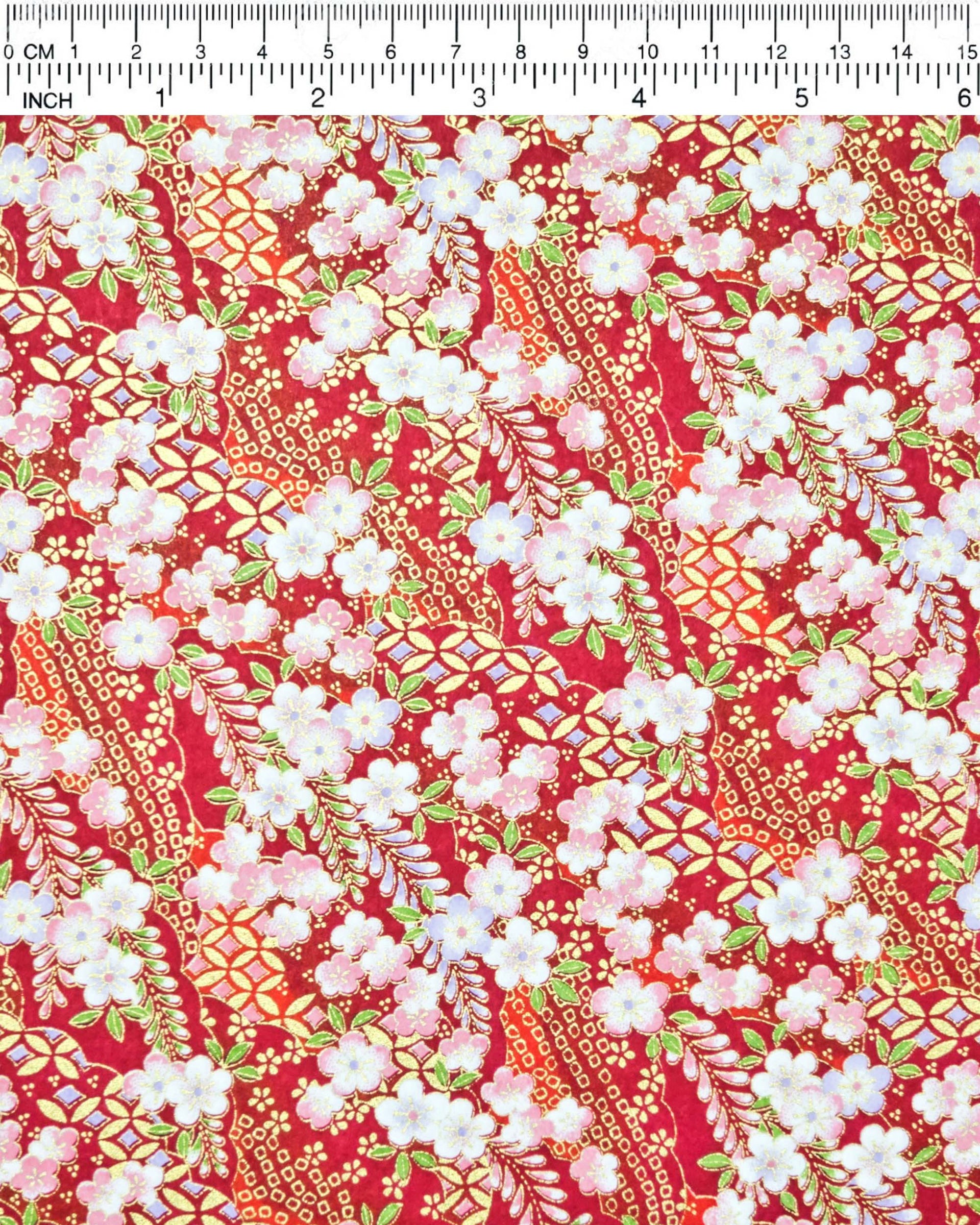 Japanese chiyogami paper featuring pink and purple plum blossoms and pink, green, and purple wisteria on a red background with metallic gold details.