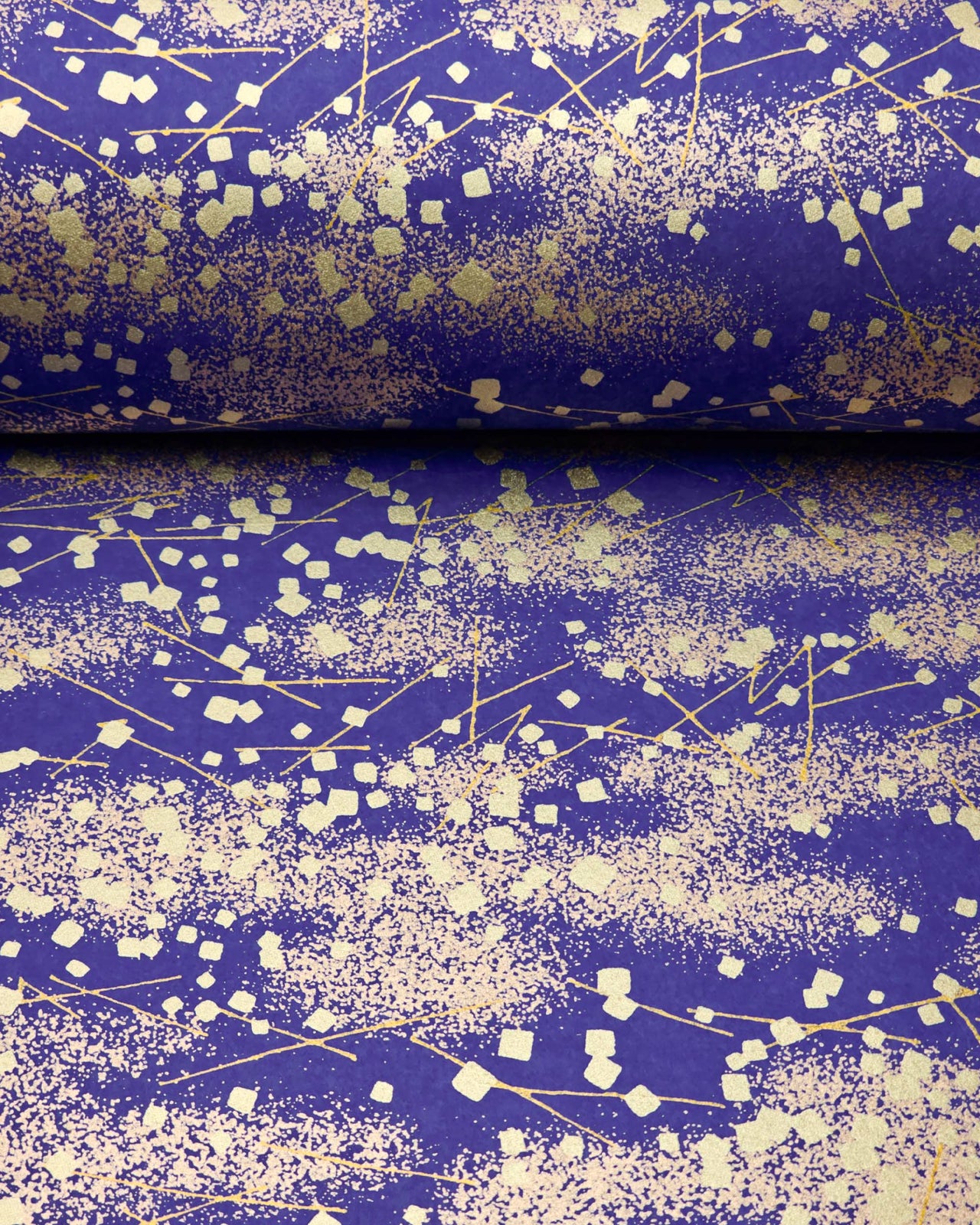 Japanese chiyogami paper featuring scattered metallic gold geometric shapes and fine gold lines on a blue background.