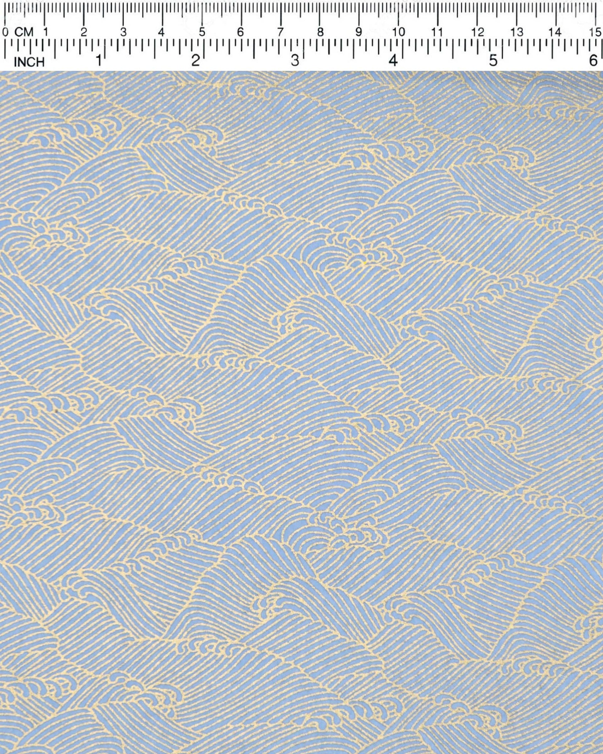 Japanese chiyogami paper featuring small metallic gold waves (aranami) on a light blue background. 