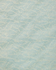 Japanese chiyogami paper featuring small metallic gold waves (aranami) on a gradient green background.