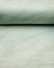Japanese chiyogami paper featuring small metallic gold waves (aranami) on a gradient green background.