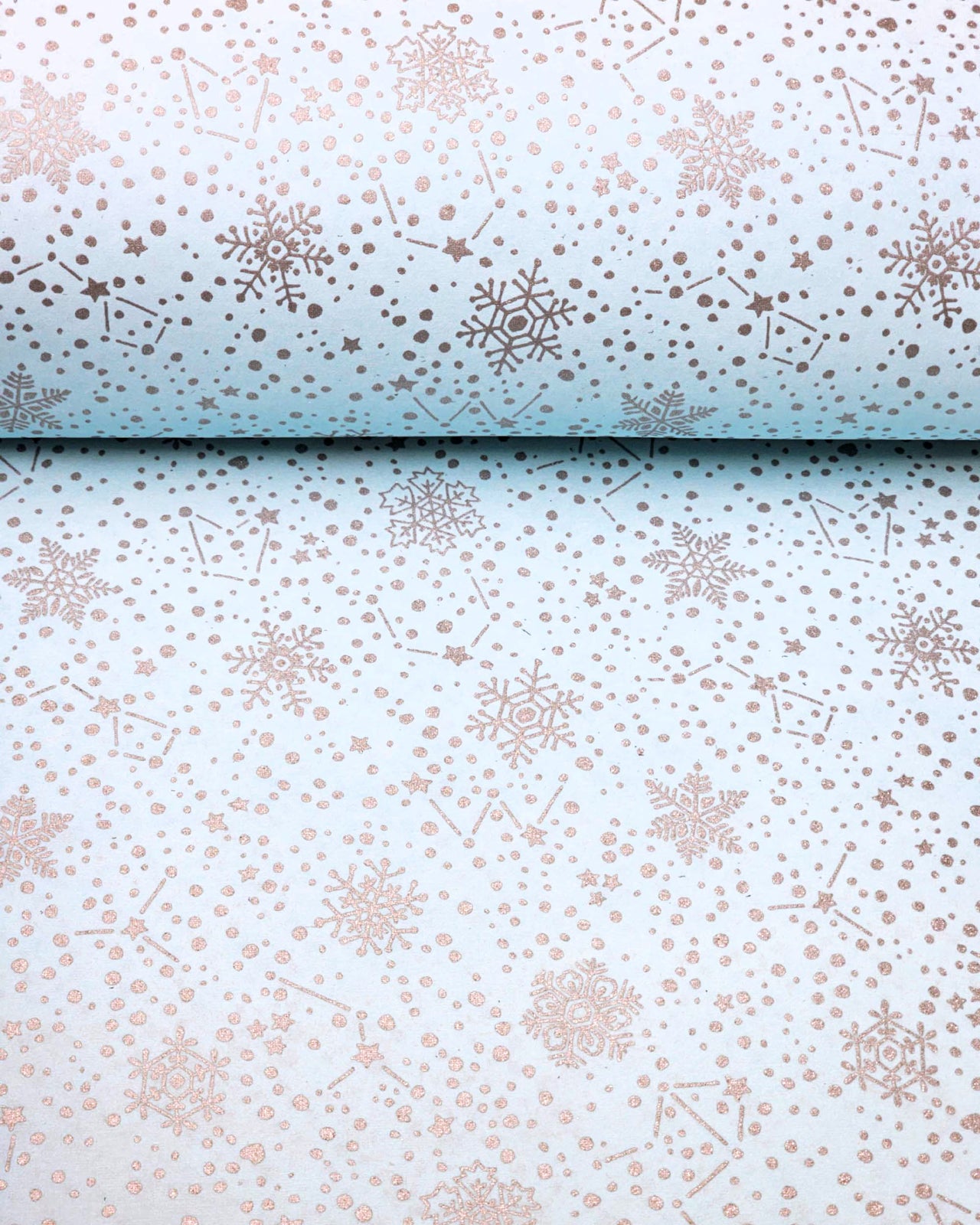 Japanese chiyogami paper featuring assorted metallic silver snowflakes and star constellations on a light blue background.