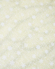 Japanese chiyogami paper featuring assorted white snowflakes and star constellations on a pearlescent light yellow background with metallic silver glitter details.