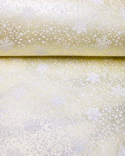 Japanese chiyogami paper featuring assorted white snowflakes and star constellations on a pearlescent light yellow background with metallic silver glitter details.